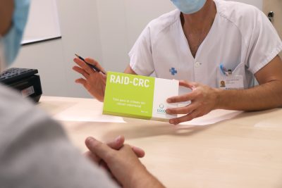 Médico entregando el kit de recogida de muestra del RAID-CRC Screen a un paciente. Foto hecha en el Hospital Josep Trueta (Girona).